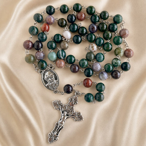 A rosary with polished green, purple, red, and white marbled beads, silver-tone chain links, a round medallion, and a detailed crucifix.