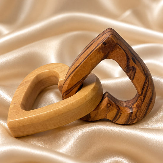 Handcrafted interlocking olive wood hearts in a detailed product view