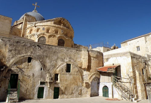 Rooftop horizontal view on a sunny day, of the Church of the Holy Sepulchre with its blue dome and golden cross.