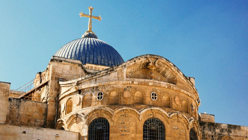 Rooftop view of the Church of the Holy Sepulchre with its blue dome and golden cross.