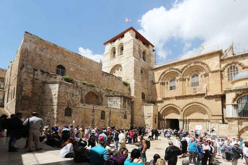 Busy entrance to the Church of a Holy Sepulchre on a sunny day.