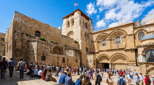Busy entrance to the Church of a Holy Sepulchre on a sunny day.