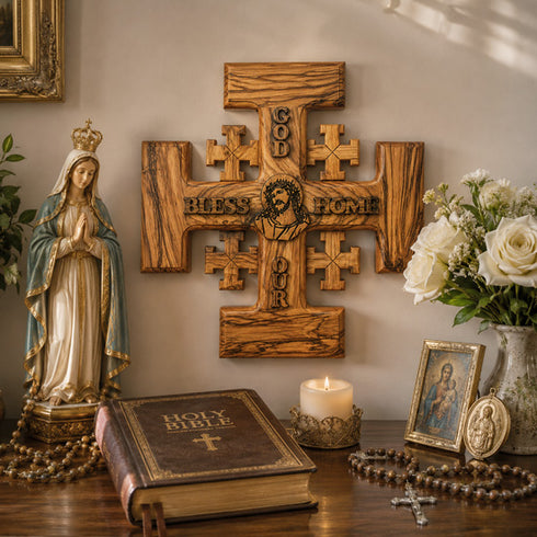 Religious decor with cross, statue, Bible, and flowers on a table.