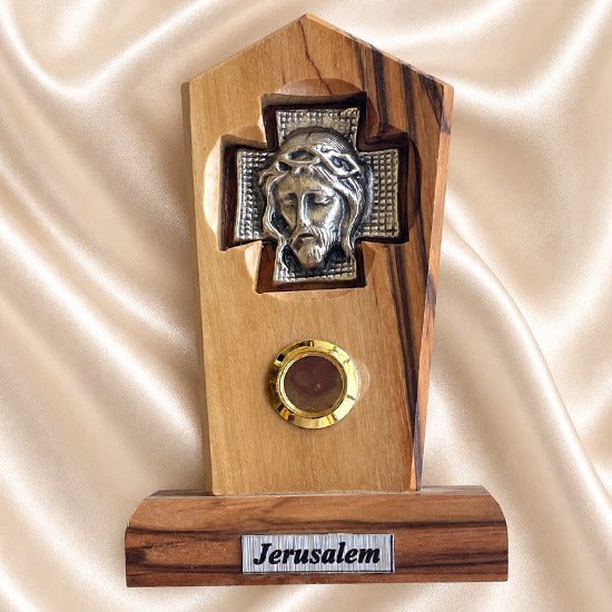 Jesus Crown of Thorns olive wood plaque with natural grain and bark edge on a neutral background