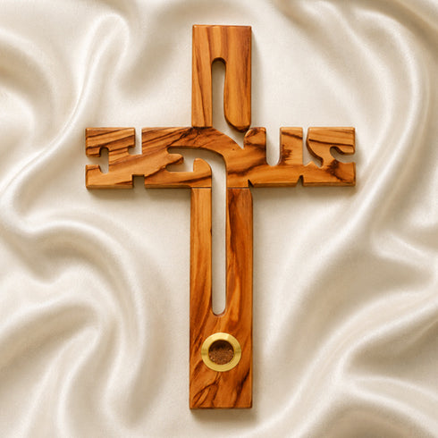 A Jesus-shaped olive wood cross with holy soil from Jerusalem, featuring detailed carvings and an embedded ring for holding holy soil.