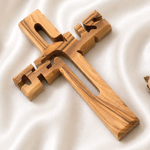 Wooden cross on a white fabric background