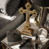 Decorative cross with Jesus on a marble surface with books, glasses, and a watch.