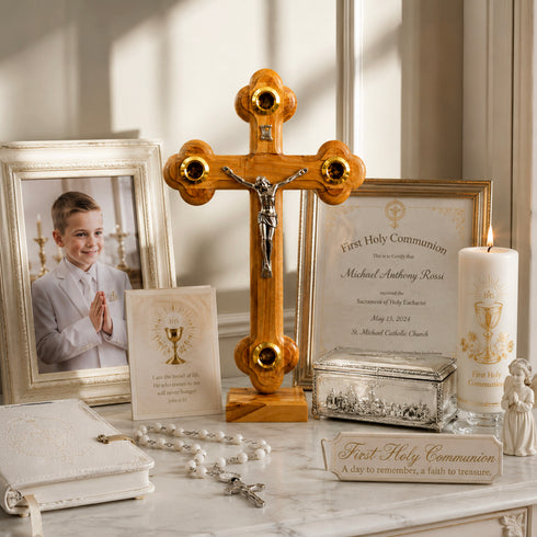 First Holy Communion items including a wooden cross, photo of a boy, and certificate on a marble surface.