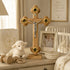 Wooden cross with Jesus figure on a shelf with toys and a baby photo in a nursery setting.