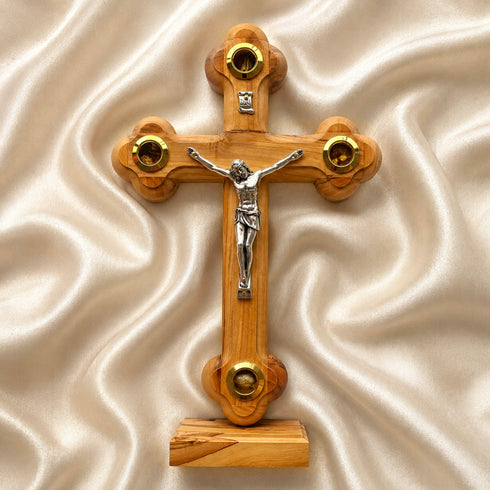 Wooden cross with a figure of Jesus on a beige fabric background