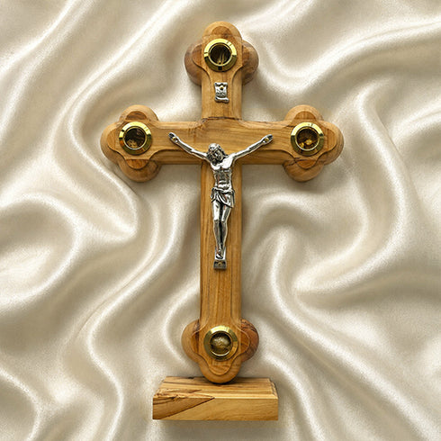 Wooden cross with a figure of Jesus on a beige fabric background
