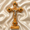 Wooden cross with a figure of Jesus on a beige fabric background