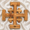 Top view of a large olive wood Crusader Cross on white satin cloth