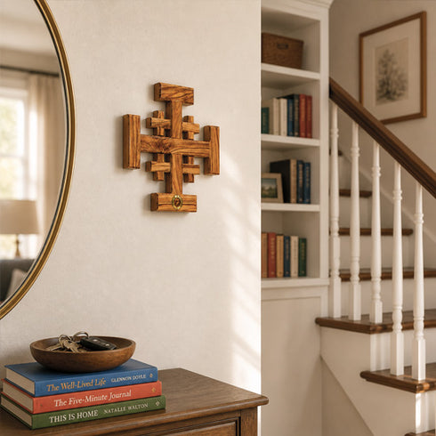 Jerusalem cross on a wall next to a mirror and staircase