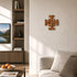 Living room with a wooden cross on the wall, a sofa, and a TV displaying a nature scene.