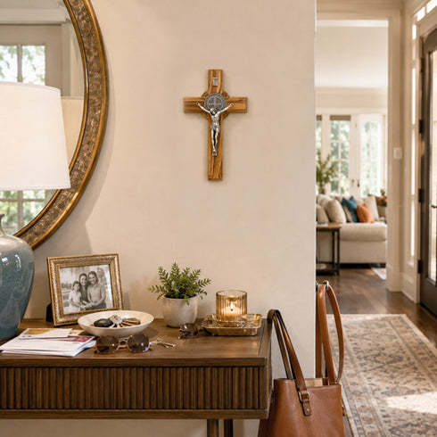 Home interior with a wooden desk, mirror, and cross on the wall.