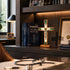 Desk with medical books, a crucifix, and framed pictures in a well-lit room.