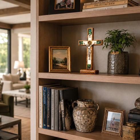 Wooden bookshelf with decorative items including a cross, books, and vases in a living room setting.