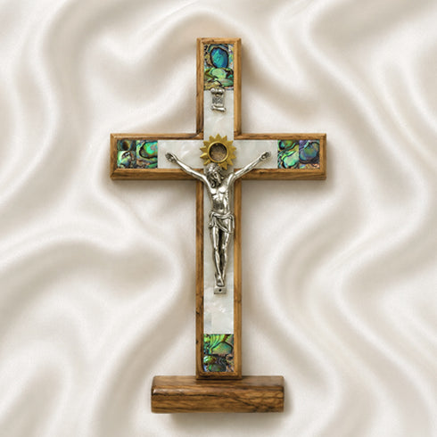 Wooden cross with a figurine of Jesus on a white fabric background