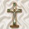 Wooden cross with a figurine of Jesus on a white fabric background