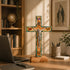Decorative cross on a desk with a laptop and books in the background