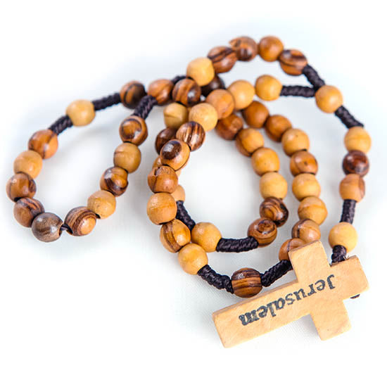 A small olive wood rosary with a black rope and a Latin cross, featuring the text 'Jerusalem' inscribed on the cross.