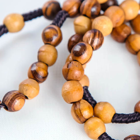 Close-up image of a handcrafted olive wood rosary.