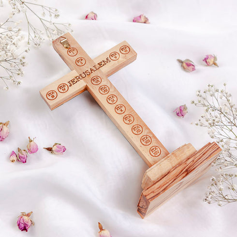 Back of latin cross for table with "Jerusalem" and Stations of Cross engraved, on white surface.