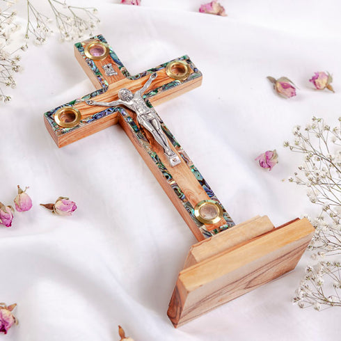 A wooden Latin cross with mother of pearl decor, featuring olive wood and adorned with dried flowers and incense.