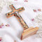 A wooden Latin cross with mother of pearl decor, featuring olive wood and adorned with dried flowers and incense.