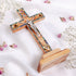 A wooden Latin cross with mother of pearl decor, featuring olive wood and adorned with dried flowers and incense.