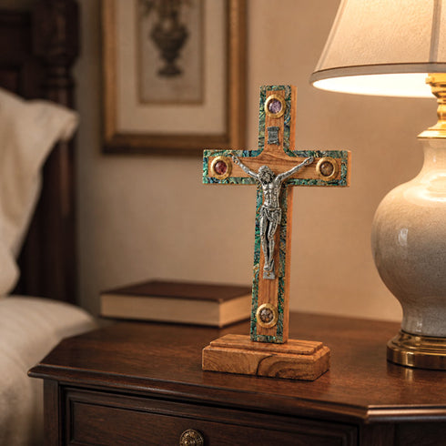 Wooden decorative crucifix on a nightable next to a lamp