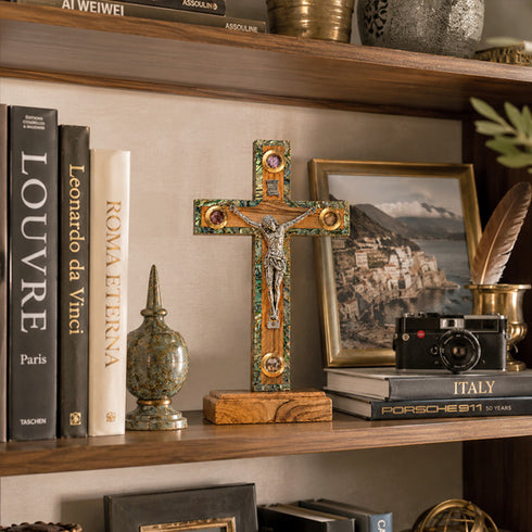 Decorative shelf with books, a cross, and a camera