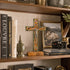 Decorative shelf with books, a cross, and a camera