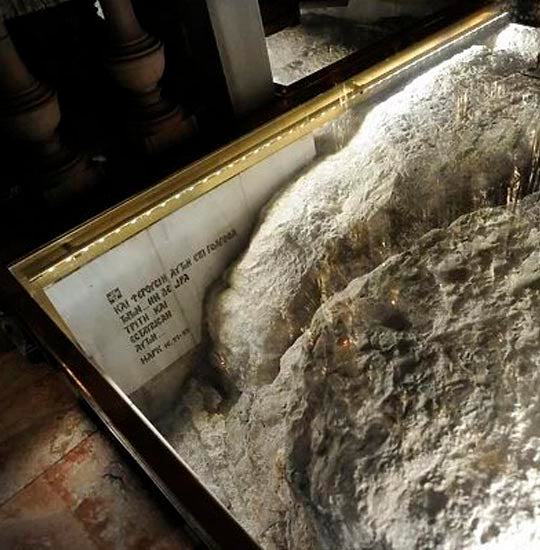 The bedrock of Golgotha, a soft white limestone in a glass protection, at Calvary.