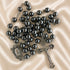 Hematite bead rosary with dark beads, oval medal centerpiece, and metal crucifix