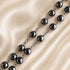 Hematite bead rosary with dark round beads and silver-toned chain links, crucifix end
