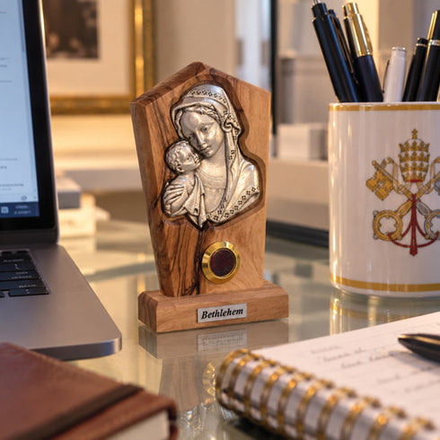Madonna and Child olive wood plaque displayed in a home office with soft background blur