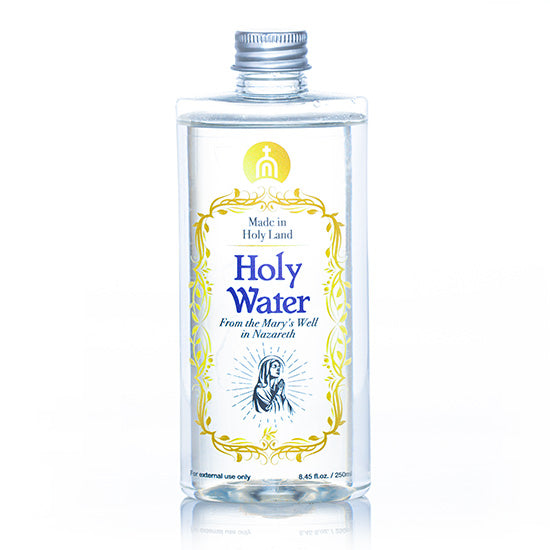 A clear bottle of Holy Water with a metal cap and a label featuring gold, blue and black text.
