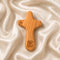 Wooden comfort cross on a textured beige surface