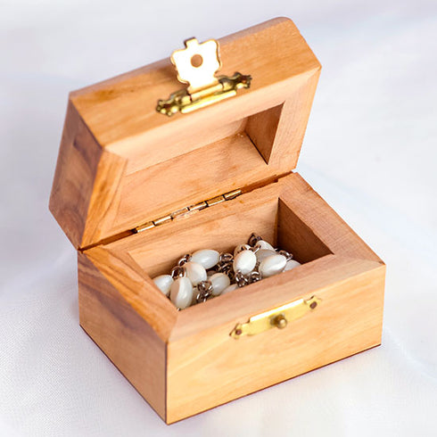Mother of Pearl rosary placed inside an olive wood box on a white background.