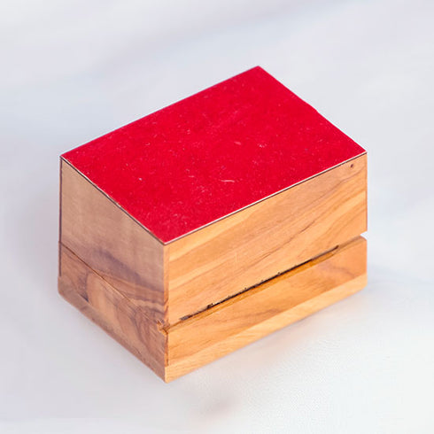 Bottom of an olive wood box with red cloth, placed on white background.