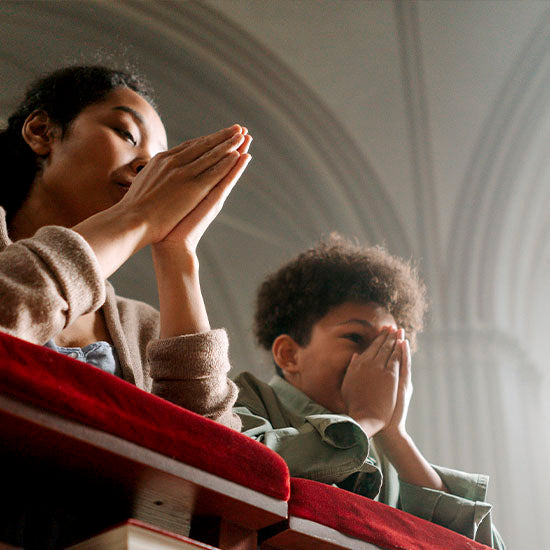 Mother and son praying in a Church