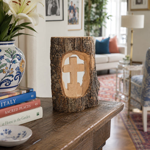 Wooden log with a cutout cross on a wooden surface in a living room.