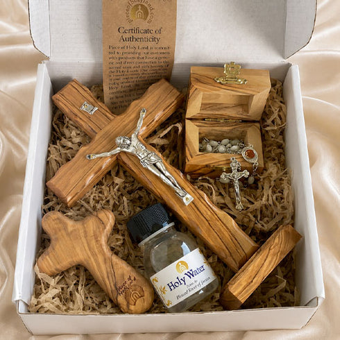 Gift set inside open box: wooden cross, rosary, Holy Water bottle, authenticity certificate