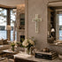 Living room with a cross on the wall, books, and flowers.