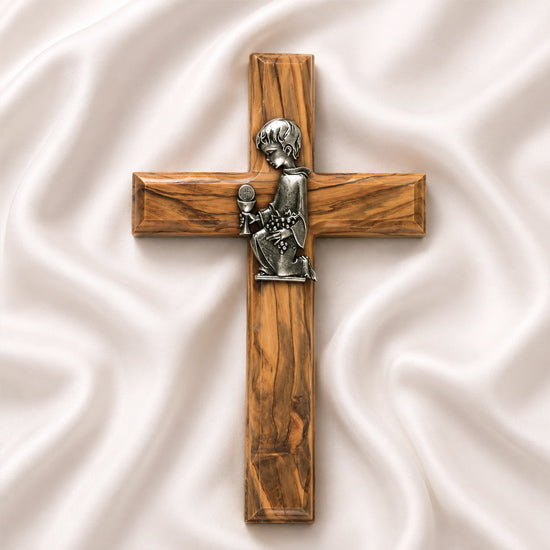 A handcrafted olive wood communion cross with a metal emblem of a praying boy on it.