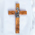 A handcrafted olive wood communion cross with a metal emblem of a praying boy on it.