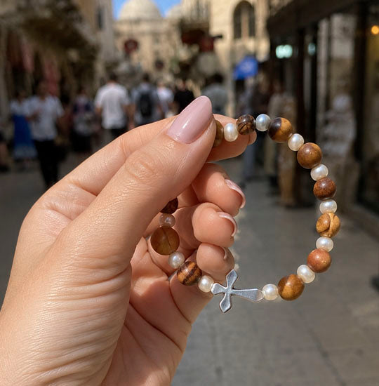 Woman's hand showing a bracelet on a street