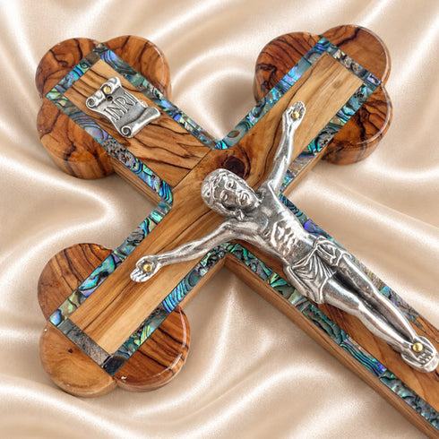 Close view of the corpus on an olive wood budded crucifix with abalone inlay